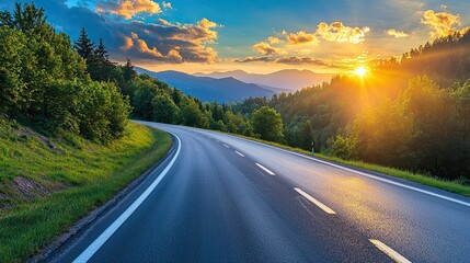 beautifully curved asphalt road stretching through a scenic landscape at sunset. The road is bordered by lush green trees and mountains