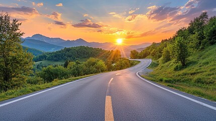 Wall Mural - beautifully curved asphalt road stretching through a scenic landscape at sunset. The road is bordered by lush green trees and mountains