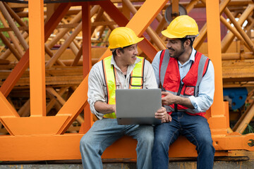 Wall Mural - Happy Asia engineer man worker use tablet computer and India engineer man use walkie talkie working with crane spare part background	