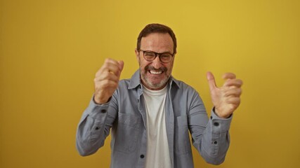 Sticker - Hispanic man middle age wearing glasses standing celebrating happy winner win victory smile expression over isolated yellow background with joyful triumph and positive energy