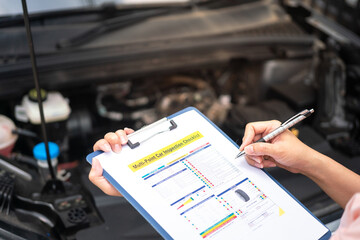 Wall Mural - close-up at a mechanic foreman's hand is checking on multi-point car service guideline checklist for
