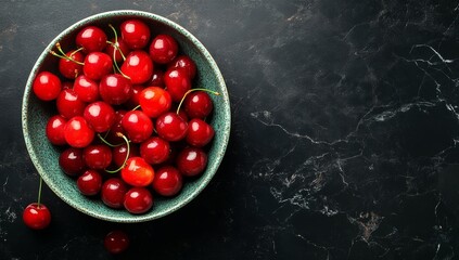 On a black background, cherry in a bowl, top view, copyspace