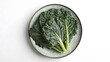 © Borasca - Fresh kale leaves on ceramic plate against white background