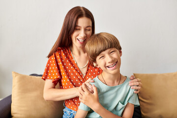 Wall Mural - A mother and her son smile warmly, enjoying their special connection in a cozy setting.