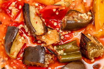 A plate of food with a variety of vegetables including eggplant, peppers