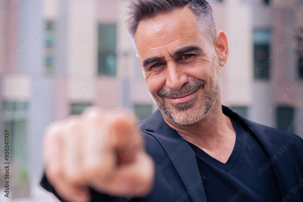 Confident middle adult pointing finger to front of logo. Smiling man pointing finger towards camera.