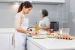 © JU.STOCKER - Senior asian mother and middle aged daughter cooking together at kitchen