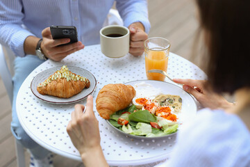 Poster - Couple having tasty breakfast in outdoor cafe, closeup