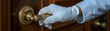 © Bantita - Bellhop's hand wearing white glove grasping hotel door handle, luxury hospitality close-up, attention to detail and service quality