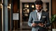 © Bantita - Close-up of hotel manager with digital tablet, elegant lobby, tech-savvy, efficient service