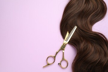 Wall Mural - Brown hair strand and professional scissors on violet background, top view. Space for text