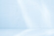 © Anchalee - Blue Background Studio with Gradient White Light on Podium stage for Product Display Present,Empty Backdrop wall texture with abstract sun light on floor concrete in pastel blue tone color for Winter