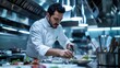 © Galib - A chef in a white coat plating a dish in a restaurant kitchen.