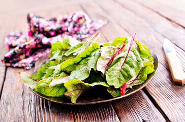 Salad leaves. Raw green leaf vegetables. Mangold leaves on plate