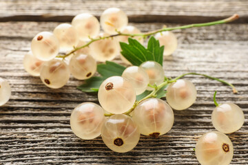 Poster - Fresh white currant berries and green leaf on wooden table, closeup