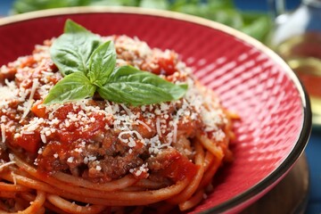 Delicious pasta bolognese with basil on table, closeup