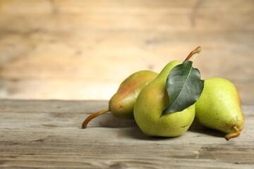 Wall Mural - Fresh green pears and leaf on wooden table. Space for text