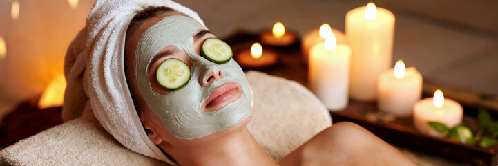 Woman relaxing with facial mask. Spa experience in candlelit setting. Self-care and relaxation concept. Beauty treatment for skin care. Ideal for wellness, spa decor, beauty ads, cards.