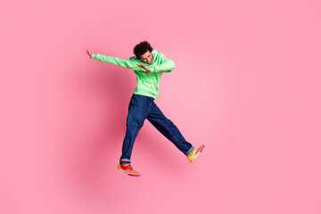 Wall Mural - Full size photo of nice young man jump headphones empty space wear green hoodie isolated on pink color background