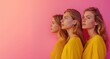 © Ruslan Gilmanshin - Three women in yellow shirts stand together on a pink background