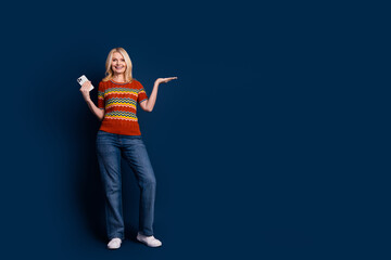 Wall Mural - Photo of nice cheerful lovely woman wear trendy clothes recommend novelty empty space isolated on dark blue color background