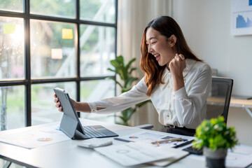 Wall Mural - excited asian businesswoman celebrating success while looking at tablet screen