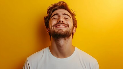 Wall Mural - A young man with a beard smiles widely against a yellow background.