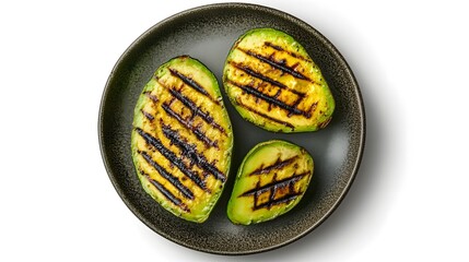 Grilled avocado halves on rustic plate with charred marks