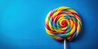 © Sayfar - fisheye lens, fun, swirl, vibrant, sugary, appetizing, lollipop, close-up, colourful, dessert, Colourful and swirl candy lollipop on a blue background captured with a fisheye lens