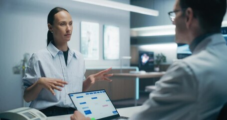 Poster - Female Patient Consults With a Male Specialist in a High-tech Medical Lab, Discussing Health Data on a Laptop. the Modern Hospital Environment Emphasizes Advanced Healthcare and Precise Analysis.