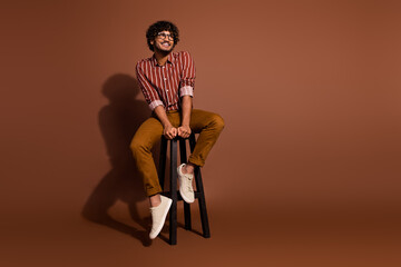 Poster - Portrait of nice young man look empty space wear striped shirt isolated on brown color background