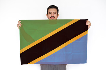 Young man holding Tanzania flag, celebration or campaigning concept, two hands and white 