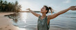 © IBEX.Media - Young woman enjoying a carefree moment with open arms on a serene beach, embracing freedom and nature at sunset