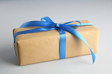 Wall Mural - Gift box with blue satin bow on light background