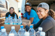 © Renata Hamuda - Smiling volunteers organizing water bottles for community service