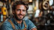 © Emile - portrait of happy young industrial man with protective wear indoors in metal workshop looking at camera