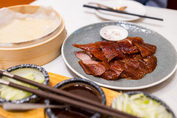 Sticker - Peking duck slice of roasted duck on the plate at restaurant