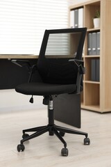 Canvas Print - Black chair and wooden desk in office