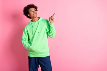 Canvas Print - Photo of nice young man indicate finger empty space wear green hoodie isolated on pink color background