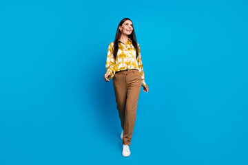 Canvas Print - Photo of cheerful successful woman wear trendy clothes walk look empty space isolated on blue color background