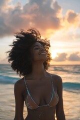 Wall Mural - A woman wearing a bikini stands on the beach, enjoying the sun and sea