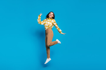 Sticker - Photo of cheerful glad lovely woman wear trendy clothes fly air jump up rejoice isolated on blue color background