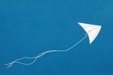 A simple white line drawing of a kite flying in the sky, with a string trailing below. The clean lines and minimalist design capture the joy and freedom of flight.