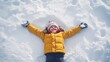 © Bernardo - Happy Child Making Snow Angels in Fresh Snow with Bright Winter Clothing