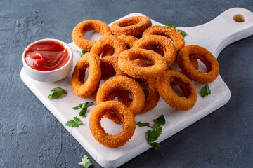 Wall Mural - Fried onion rings with mozzarella or plain. Delicious onion rings on black background