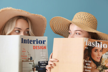 Poster - Young sisters in summer hats reading magazines on blue background, closeup