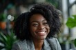 © LukaszDesign - Smiling businesswoman in an office, showcasing confidence and ambition as an HR manager and entrepreneur with curly hair