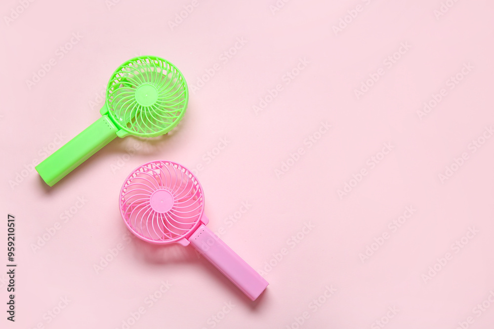 Different portable electric fans on pink background