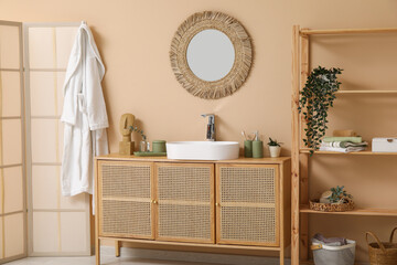 Sticker - Modern sink with bath supplies on countertop near brown wall in bathroom