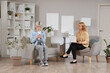 © Pixel-Shot - Female psychologist with teenage girl in headphones using mobile phone in office